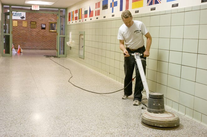 Senior custodian Peter Obernesser polishes the floors of Hughes Elementary School in New Hartford.