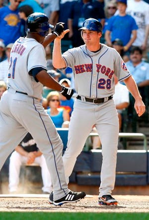 Mets' Carlos Delgado (21) is greeted at the plate by teammate Daniel Murphy (28) after the two scored off Degado's eighth-inning home run off Milwaukee Brewers pitcher Eric Gagne, during a game at Miller Park on Monday, Sept. 1, 2008, in Milwaukee. The Mets defeated the Brewers 4-2.