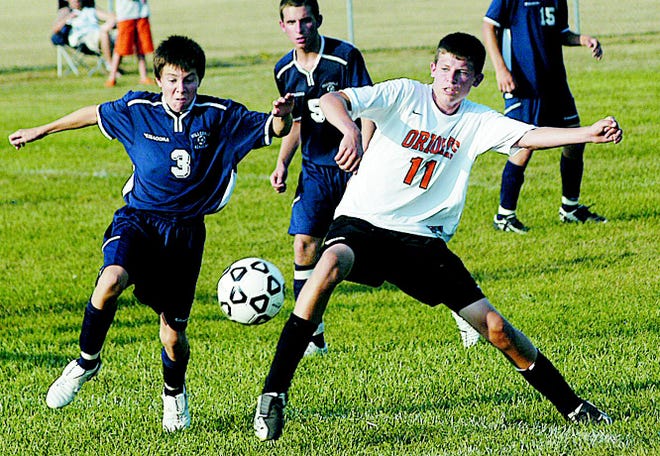 Quincy soccer player Tyler Dules battles for the ball with a Hillsdale Academy player.