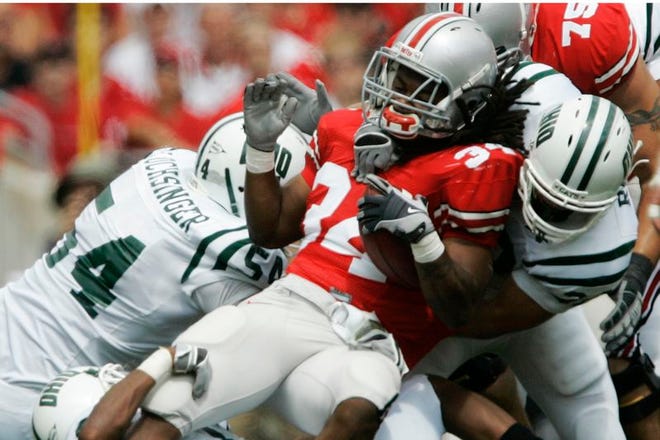 Ohio State running back Maurice Wells gets stopped by Ohio's Thad Turner (bottom) and Lee Renfro (right).