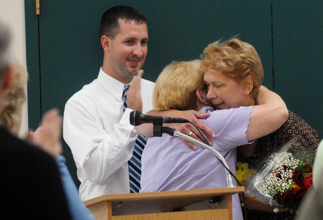 Sue Sabrowski, right, former Rose City Senior Center director is hugged by Beverly Goulet, Norwich human services director as present senior center director Michael Wolak applauds Friday, September 5, 2008 during a program celebrating the Norwich center as the 8th Connecticut senior center to achieve national recognition.