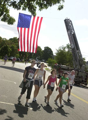 Walkers and runners approach the finish line during the 5K and 10K Officer Jamie Cochrane Memorial Road Race, which was held Sunday in Quincy.