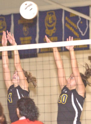 Galva’s Ashley Thomson (left) and Shannon Clark reach up for a block attempt during the Sept. 4 home match against DePue. The Lady Cats dropped the non-conference match in three games.