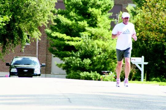 Dave Morland of Galva (right) crests a street hill on Galva's northwest side on Sept. 5 during a training run in preparation for a marathon he plans to run later this month.