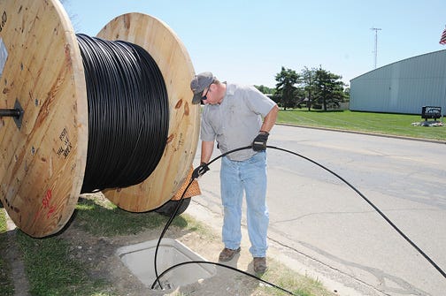 Darin Foote of D&P?Communications works on fiber optic cable installation in July along Russell Road in Tecumseh.