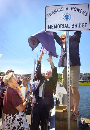 Clare Sheehan Powers watches as state Rep. Frank Hynes, center, and Russell Clark unveil a sign during the dedicating of the Julian Street bridge to the late Francis Powers.