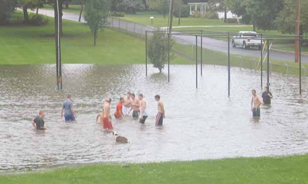 Rainwater backed up into the softball diamond at the north end of Windmont Park Saturday. These young people — and a dog — took advantage of the opportunity to do some wading.