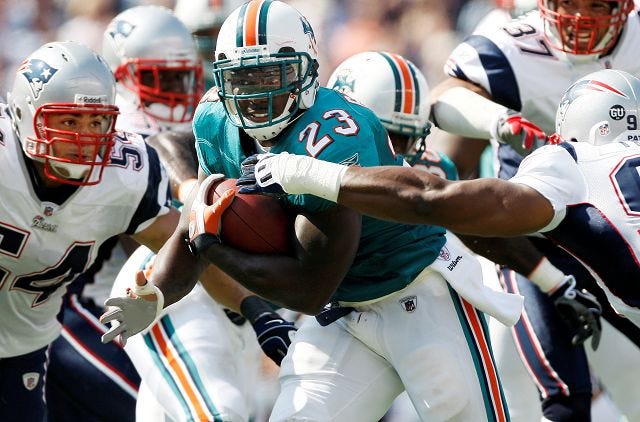 AP Photo
Miami Dolphins running back Ronnie Brown (23) runs past New England Patriots defenders Tedy Bruschi, left, Jarvis Green, right, and Rodney Harrison (37) for a touchdown during the second quarter of New England's 38-13 at Gillette Stadium in Foxborough, Mass. Sunday.