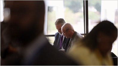 MOTIVATED  Dr. Ron Davis, right, reviewing notes before a speech in July.