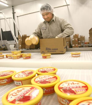 Bernabe Mendoza of Chelsea packages boxes of Hummus in the Tribe warehouse in Taunton in this 2007 file photo.