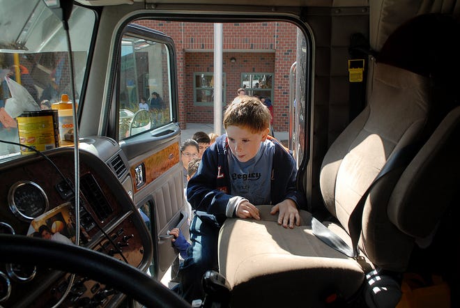 Fifth-grader Chris Keegan climbs into the cab of a moving truck Tuesday at Stanley Elementary School in Waltham.