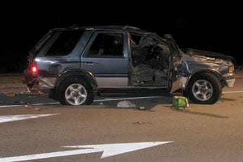 A wrecked Isuzu SUV sits in the southbound lanes of College Road on Sunday night.