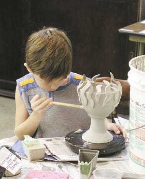 Carson McGhee puts the finishing touches on a piece of pottery he created at last years Hot Pots/Cool Art.