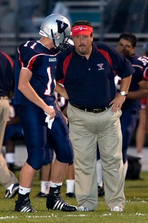 Vanguard quarterback Quinton Hitchcock gets instructions from head coach Greg Bigham in the season opener against West Port. Bigham was fired Friday after starting the season 0-4.