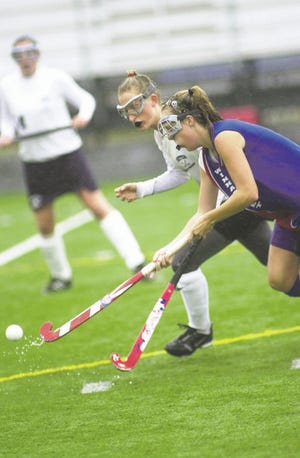 Exeter High School's Amber Evans and Winnacunnet’s Sarah Carter battle for the ball during Class L field hockey action last week. WHS defeated Exeter, 2-1.