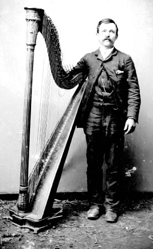 Angelo, standing with his harp at left, was sold to a trade trafficker in New York in 1867. His harp is in the Siskiyou County Museum today.