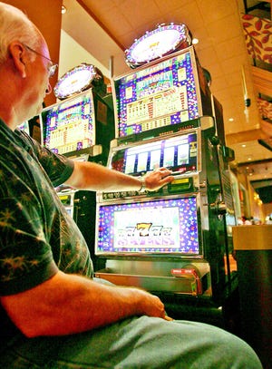 John Sylvia of Taunton plays the slot machines during a trip to Foxwoods in this 2007 file photo. Plans for a $1 billion resort casino in town could run out of luck as the economy continues to falter, a gambling researcher says.