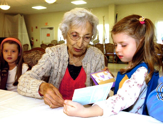 Elise Puliafico, 5, West Bridgewater, a member of Troop 205 shows her great-grandmother Frances Puliafico a card that she made for her, as Elise’s sister, Valerie Puliafico, 7, a member of Troop 818 looks on.