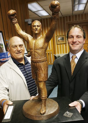 Peter Marciano Sr., the brother of Rocky Marciano, and Peter’s son Stephen, admire a model of the proposed 24-foot-tall statue at Brockton City Hall recently.