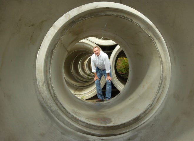 Scituate Concrete Pipe CEO Bill Hoffman peers through a concrete pipe.