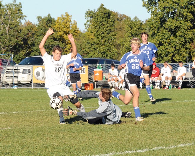 Adrian goalkeeper Topher Baucher dives as he attempts to make a save in front of Tecumseh forward Scott Corley during Thursday’s SEC?contest. Tecumseh defeated the Maples 4-0.