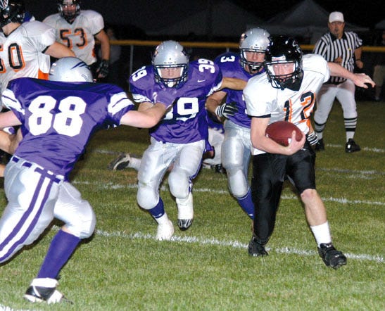 Falcon quarterback Adam Johnson eludes a host of Minutemen defenders en route to picking up a first down Friday.