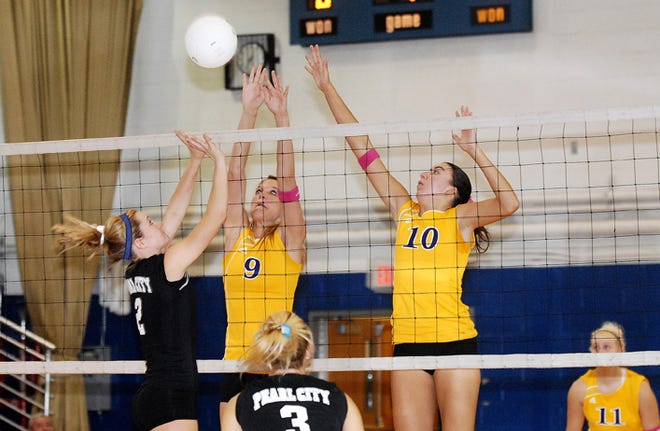 Stefanie Weiss / The Journal-Standard  
Pearl City's Codie Buss (left) hits the ball over the net as Orangeville's Kassie Martin (middle) and Sam DeVries (right) tries to block it Saturday at Durand's volleyball invitational.