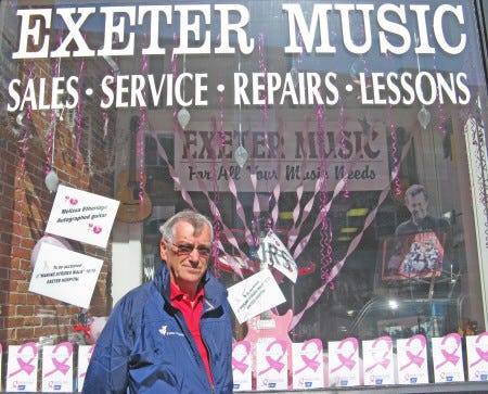 Fred Muscara, co-chairman of the Exeter Making Strides Committee, stands in front of a guitar signed by Melissa Etheridge shown in the display of Exeter Music. The guitar will be auctioned off during the Making Strides against Breast Cancer Walk on Sunday, Oct. 19.