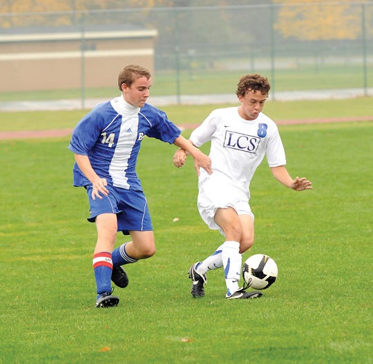 Lenawee Christian’s Jeremy Winstead keeps the ball away from Taylor Baptist Park defender Tim Short during Wednesday’s district semifinal. Winstead finished the game with four goals as LCS?won 8-0.