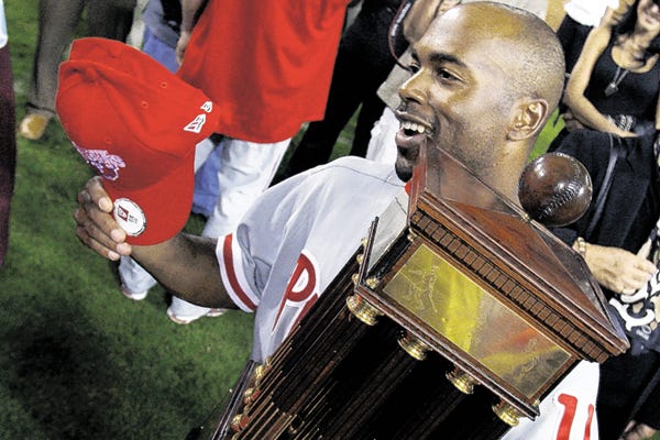 Philadelphia Phillies' Jimmy Rollins holds the winning trophy after the ninth inning in Game 5 of the National League baseball championship series against the Los Angeles Dodgers Wednesday, Oct. 15, 2008, in Los Angeles. The Phillies won the game 5-1 to win the series.