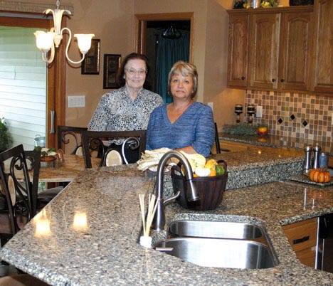 Phyllis Ryan, left, co-chairman of the Pontiac Woman’s Club house walk on Thursday, stands next to Vickie Fogarty in Fogarty’s newly remodeled kitchen. Fogarty’s home at 903 Debra Lane will be on the walk.