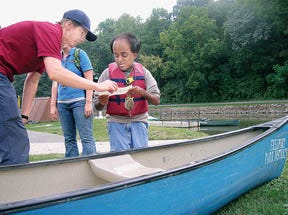 Jennifer Nowicki, Oakdale Nature Preserve outdoor education coordinator, helps camper Alex Ackman identify the part of the canoe pictured on his paper.