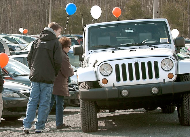 Ryan Johnson, 17, of Brockton looks over a 2007 Jeep Wrangler with his mother Barbara Johnson at the Classic Chrysler Jeep dealership along Route 44 in Raynham in February, 2007.