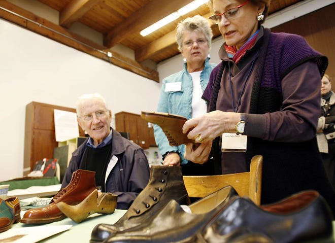 John Learnard, from left, Jill Wainright and guest curator Wendy Tarlow Kaplan look through a collection of antique shoes for a Fuller Craft Museum exhibit “The Perfect Fit,” a celebration of Brockton’s shoe making history that starts June 2009.