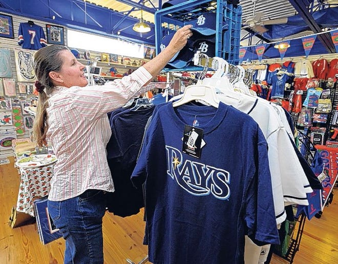 Susan Henning looks for Tampa Bay Rays merchandise at the Proud Gator in Lakeland on Tuesday. A USF and Bucs fan, she said she is jumping on the Rays bandwagon.