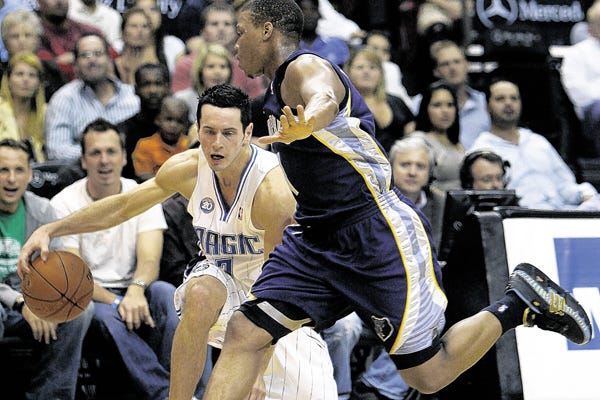Orlando Magic guard J.J. Redick, left, drives around Memphis Grizzlies guard Kyle Lowry, during the first half of an NBA preseason basketball game in Orlando, Fla., Wednesday, Oct. 22, 2008.