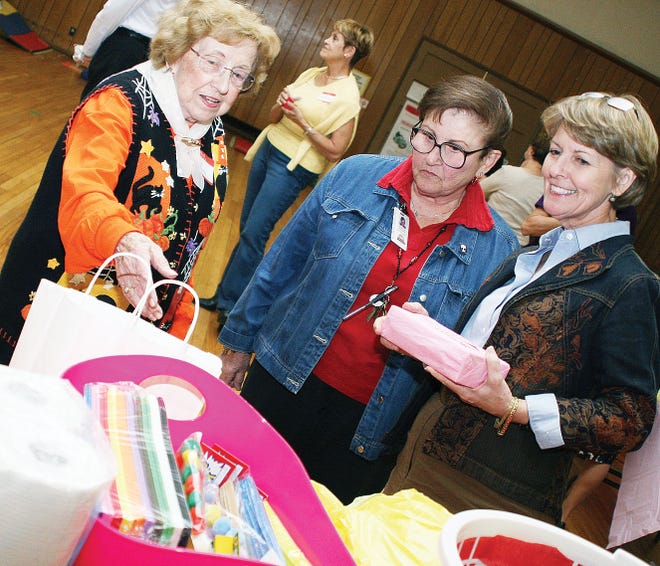 Former Elm Grove Elementary School teacher Ruth Davis, from left, who is also a member of Altrusa International of Oak Ridge, Preschool and Willow Brook Elementary Psychologist Blanche Dresner and Preschool Principal Marian Phillips examine some of the items brought to the Preschool for the community shower.