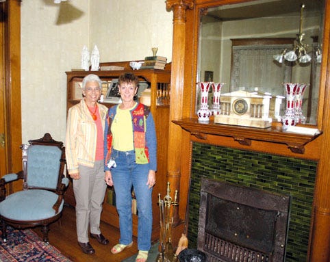Linda Dionne, left, and Martha Slavik, members of the Yost House Museum Restoration Committee, stand in one of the parlors of the Yost House, which will be on today’s Pontiac Woman’s Club house walk “Fall Tour of Homes” from 2 to 4:30 p.m. and 6 to 8:30 p.m.