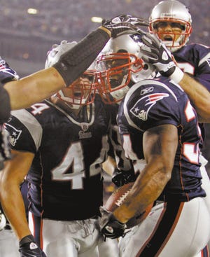 New England Patriots running back Sammy Morris (right) is congratulated by teammates after scoring a touchdown during the second quarter of Monday’s game against the Denver Broncos at Gillette Stadium.