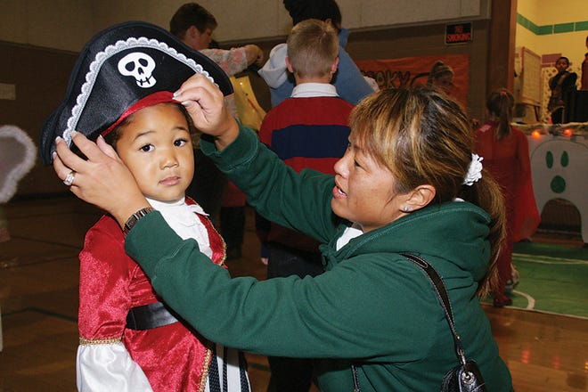 Alexis Ford, 4, of Adrian has her hat adjusted by her mom, Pam Ford, on Friday evening during Freaky Friday at Adrian’s Piotter Center. Local children got a head start on Halloween, with the event offering a haunted house, costume contests, games, candy and treats, all sponsored by the Adrian Parks and Recreation, the Boys and Girls Club and the Siena Heights University sports management program.