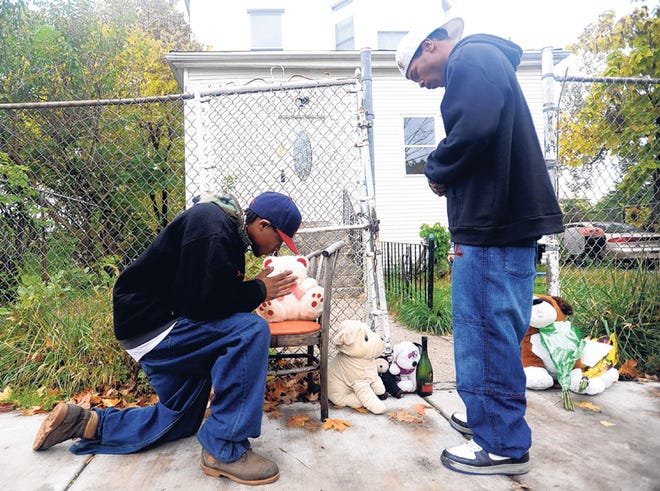 JEREMY WALKER, RIGHT, AND BOBBY MOORE pray at a makeshift memorial outside the home belong to the family of Oscar-winning actress Jennifer Hudson on Saturday.