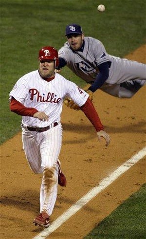 Philadelphia Phillies' Eric Bruntlett runs past a diving Tampa Bay Rays' Evan Longoria to score the game winning run from third on a hit by Carlos Ruiz during the ninth inning of Game 3 of the baseball World Series in Philadelphia, Sunday, Oct. 26, 2008. The Phillies won 5-4 to take a 2-1 lead in the series.