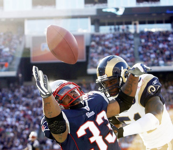 Patriots running back Kevin Faulk reaches for a pass as St. Louis' Will Witherspoon tackles him during the third quarter.