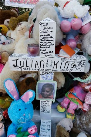 A cross with a photo of 7-year-old Julian King, nephew of singer and Oscar winner Jennifer Hudson, stands at a makeshift memorial outside the home of Darnell Donerson, Hudson's mother, in Chicago. King was found shot to death inside an SUV Monday on the city's West Side. Donerson and her son, Jason Hudson, were found shot to death inside the home on Friday, Oct. 24.