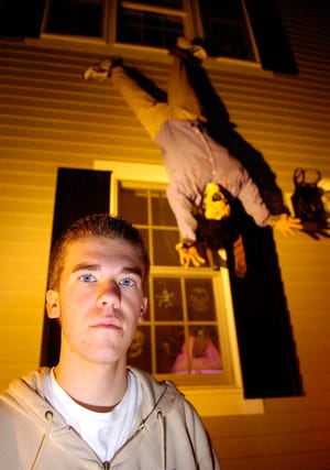 Dennis Harkins Jr., who turns 16 today, stands in the front of his home at 11 Wilbur St. in Easton that’s well-dressed for Halloween, including a dummy that hangs from a second-floor window. The Oliver Ames sophomore says the spooky fest is like a birthday party for him.