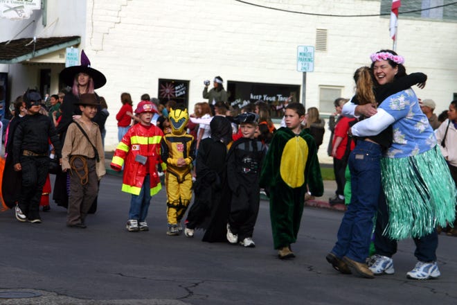 Students and teachers march in costume in the shools' parade.