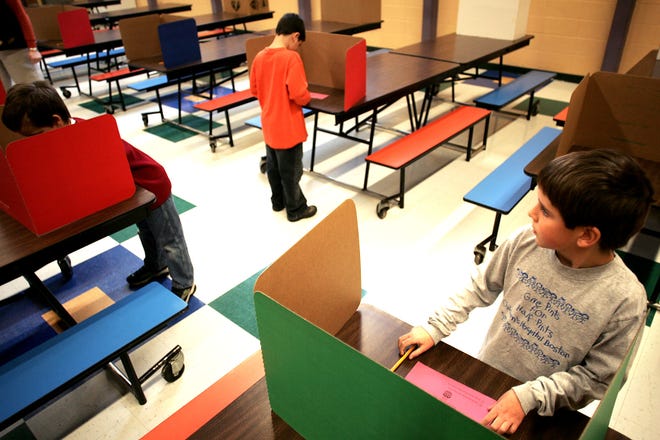 LaLiberte Elementary second grader Matt Nelson, 8, right, casts his ballot in Monday morning’s mock election inside the school’s cafeteria. For full coverage of how the adults voted Tuesday, go to raynhamcall.com