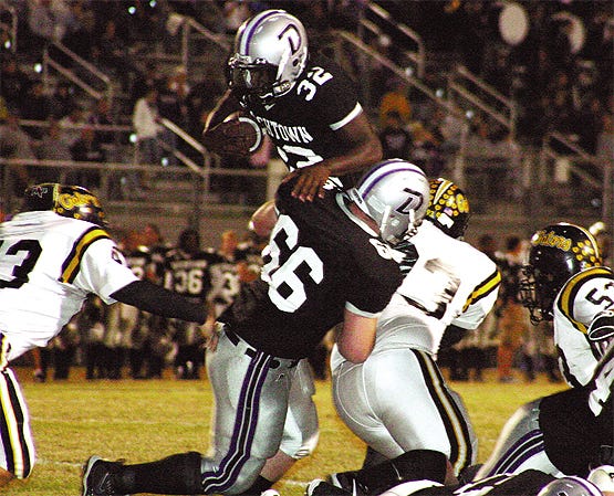 Dutchtown’s Eddie Lacy gets a boost from Colby Crysel to go over the top of St. Amant’s Zach Whittington, Justin Bumgardner and Marvin Martin on a 1-yard touchdown run in the first quarter of the Griffins 56-21 victory Friday night. Lacy finished with 55 yards and two touchdowns on five carries.