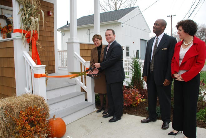 Lt. Gov. Timothy Murray, second from left, is joined by South Middlesex Correctional Center Superintendent Kelly Ryan in cutting the ribbon on the new reunification house Wednesday on Western Avenue in Framingham. Looking on are Harold W. Clarke, Department of Correction commissioner, and Elizabeth Heffernan, Public Safety and Security Undersecretary of Criminal Justice.