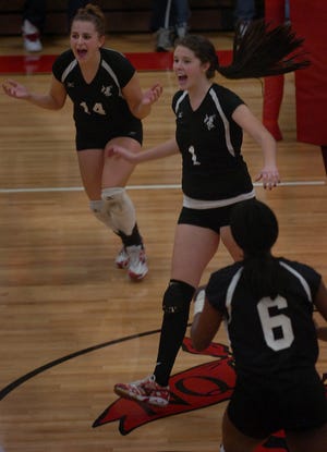 North Quincy's Ashley Kostka (14), Amanda Kelley (1) and Nerry Francois (6) celebrate a point.